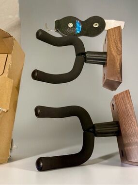 Wall-Mounted Guitar Hangers with Black Foam Arms and Wood Base